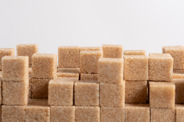 Wall of refined cane sugar cubes white background.