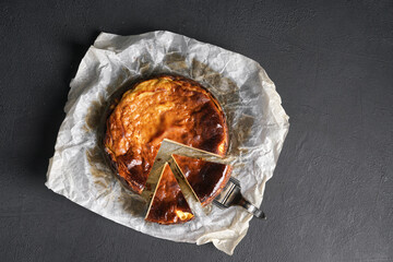 Top view of basque burnt cheesecake liced on black table. copy space