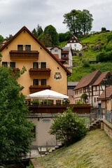 A small town with a yellow house and a white umbrella on the front. The house is surrounded by trees and has a balcony