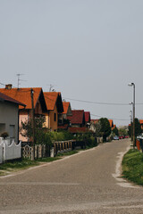 Houses with a tiled roofs in Balkans. Beautiful trees with white flowers blooms in yards. Bijeljina...