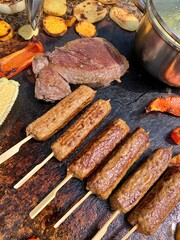steak, outdoor grill, grilled potatoes, peppers, cevapcici, minced meat on toothpicks