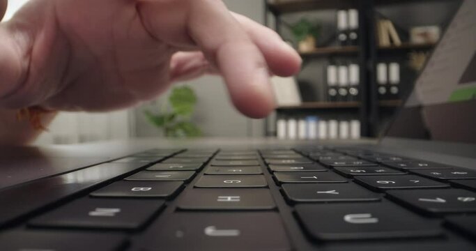 Male hands typing email on computer laptop keyboard at workplace, working, browsing website. Close-up shot
