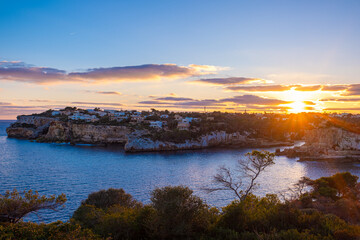 Beautiful panoramic view of Santanyi, Mallorca, Spain at golden hour of sunset. A town in the rays of the setting sun, beautiful sky and calm sea