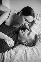 Young couple hugging. A man and a woman admire each other. A beautiful woman hugs her man. Young man and woman on the bed.