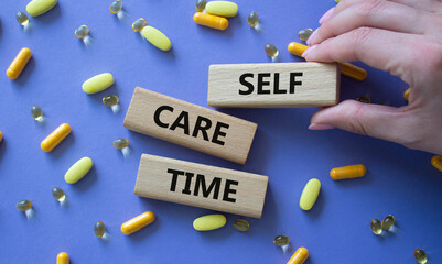 Fototapeta premium Self-care Time symbol. Concept words Self-care Time on wooden blocks. Beautiful purple background with pills. Doctor hand. Healthcare and Self-care Time concept. Copy space.