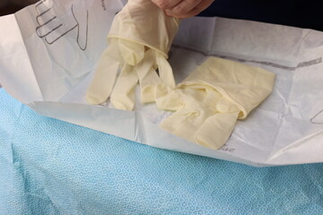 Professional preparing to a procedure wearing a sterile gloves. Gloves in the sterile pack been...