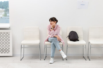 Woman sitting on chair and waiting for job interview indoors