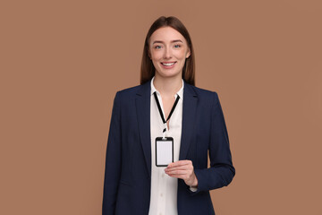 Woman with blank badge on light brown background