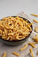 Dry Casarecce Pasta in a Bowl, side view.