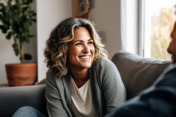 middle aged woman sitting on sofa talking to her husband