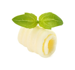 One tasty butter curl and basil leaves isolated on white
