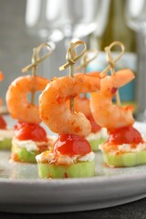 Tasty canapes with shrimps, vegetables and cream cheese on table, closeup