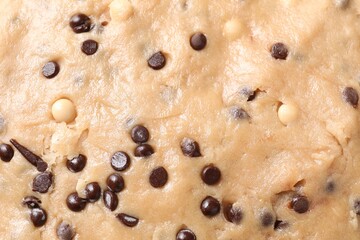 Raw dough with chocolate chips as background, top view