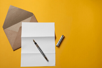 Blank sheet of paper, letter envelope and pen on orange background, top view. Space for text