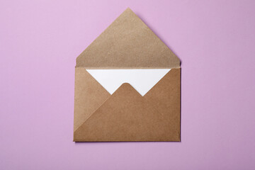 Letter envelope with card on violet background, top view