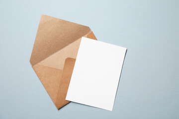Letter envelope and card on grey background, top view. Space for text