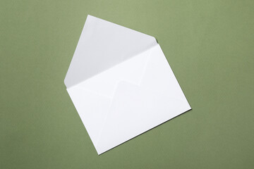 Letter envelope on green background, top view