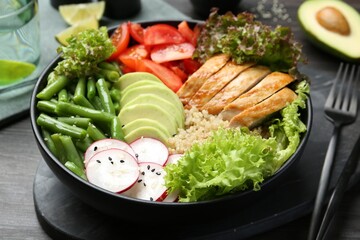 Healthy meal. Tasty products in bowl on black wooden table, closeup