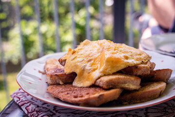 Egg coated fried bread, salty French toast with an omelette, outdoors brunch