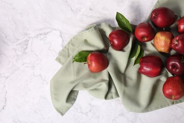 Fresh ripe red apples with leaves on white marble table, flat lay. Space for text