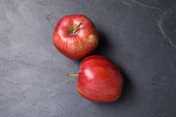 Fototapeta na wymiar Ripe red apples on black textured table, flat lay