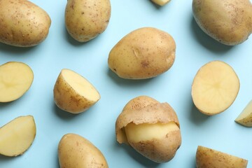 Fresh raw potatoes on light blue background, flat lay