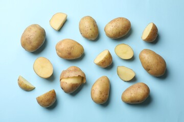 Fresh raw potatoes on light blue background, flat lay