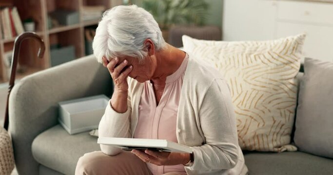 Senior, woman and sad with photograph on couch for thinking, nostalgia and remember memory of history or past. Elderly person, home and thoughts on sofa with picture, missing and mourning with grief.
