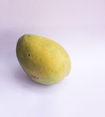 A tropical Nigerian fresh mango on its side on a white background