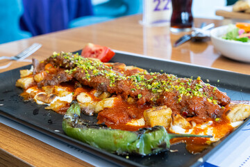 Turkish kebab with pistachios served with sliced pita bread, yoghurt and tomato sauce.