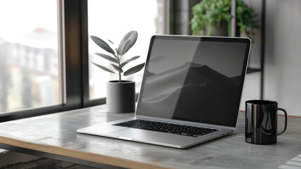 Open laptop on desk with plant and coffee mug, in modern office space