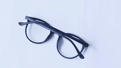 Eye glass with black frame on white background, copy space, concept of style, fashion, office, study and work.