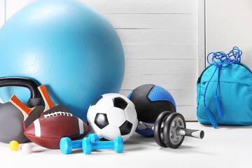 Many different sports equipment on white table