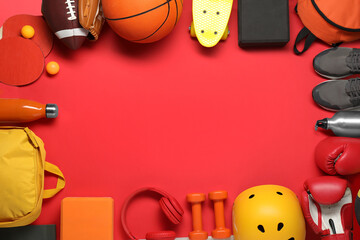 Frame made of different sports equipment on red background, flat lay. Space for text