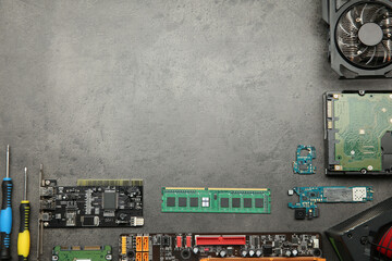 Graphics card and other computer hardware on grey textured table, flat lay. Space for text