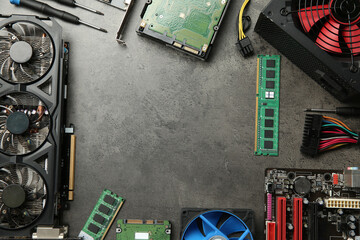 Frame of graphics card and other computer hardware on grey textured table, flat lay. Space for text