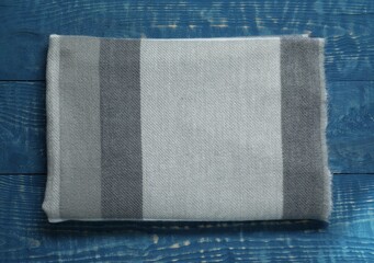 Soft scarf on blue wooden table, top view
