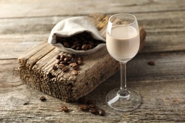 Coffee cream liqueur in glass and beans on wooden table