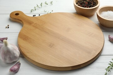 Cutting board and different spices on white wooden table