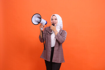 Young indonesia girl in hijab angry facing right side up shouting using mic holding megaphone...