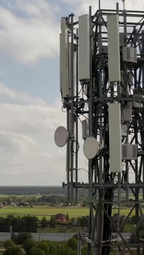 Telecommunication tower 5G near small town and village. Telecom tower antenna and satellite transmits the signals of cellular 5g and 4g mobile signals. High quality 4k footage Vertical Shot.