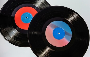 Three vinyl records with blue, red, and pink center labels on a white background.