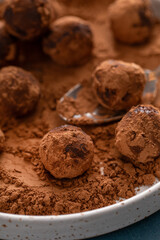Artisanal chocolate truffles dusted with cocoa powder on a plate with a spoon