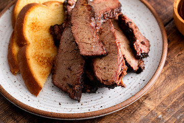 Juicy smoked brisket slices with toast on plate