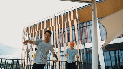 Hipster perform break dancing while partner dancing together at corridor, modern mall. Hip-hop music dancer practice footstep and move to music. Outdoor sport 2024. Active, energetic dance. Endeavor.