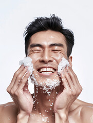 Happy asian man exfoliating face using rock salt