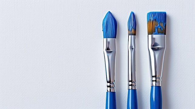 A blue paintbrush and a paintbrush against a white backdrop