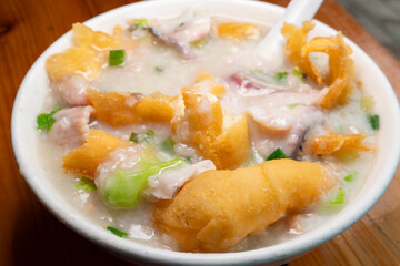 angle view fish slices and pork porridge with deep-fried Chinese donuts at horizontal composition
