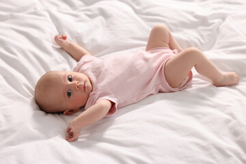 Cute little baby lying on white sheets