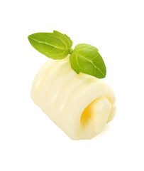 One tasty butter curl and basil leaves isolated on white